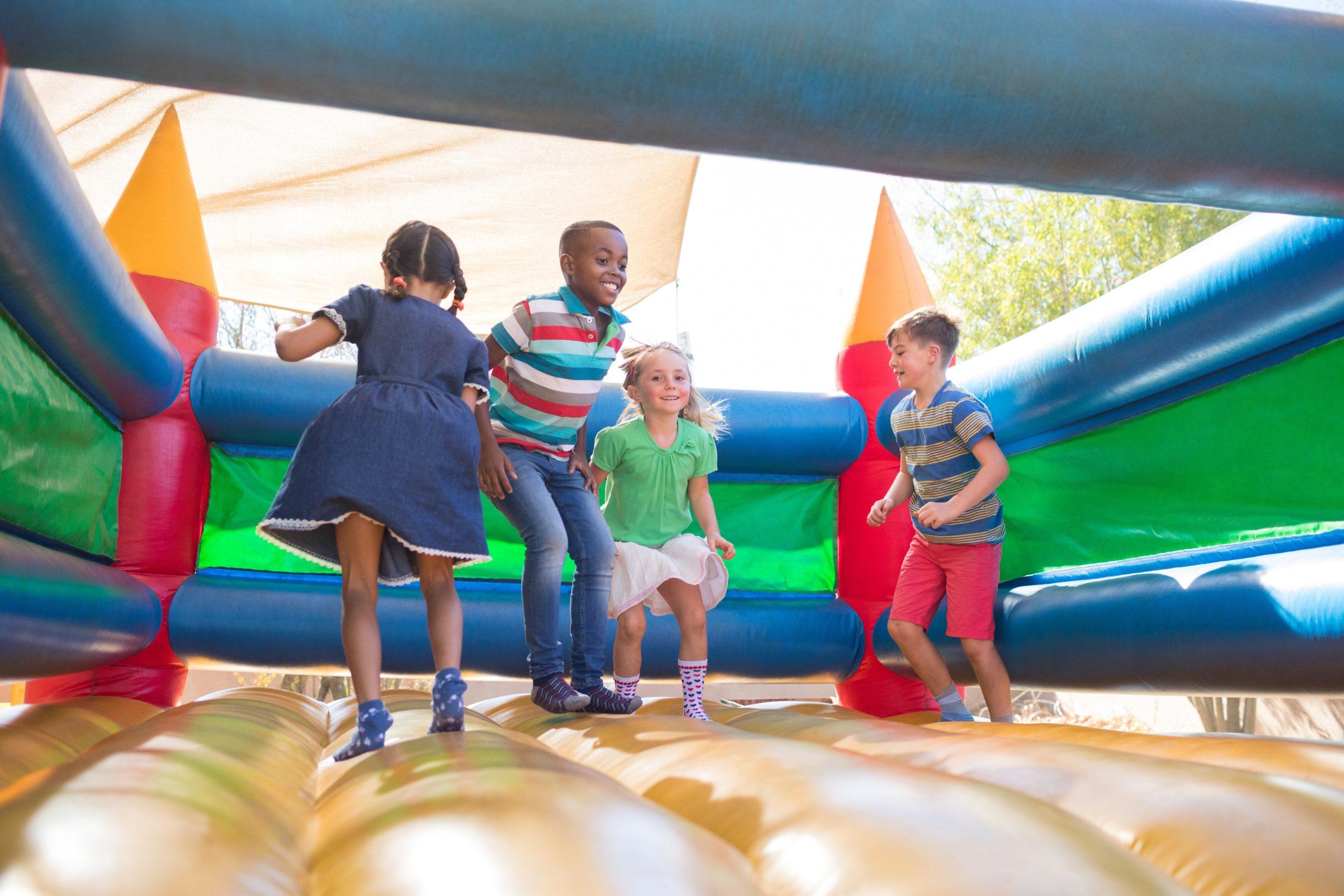 Children enjoying a colorful bounce house at an outdoor party